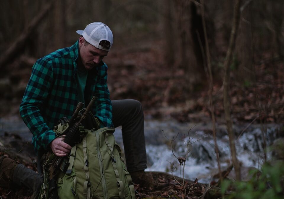 a man sitting on the ground in the woods