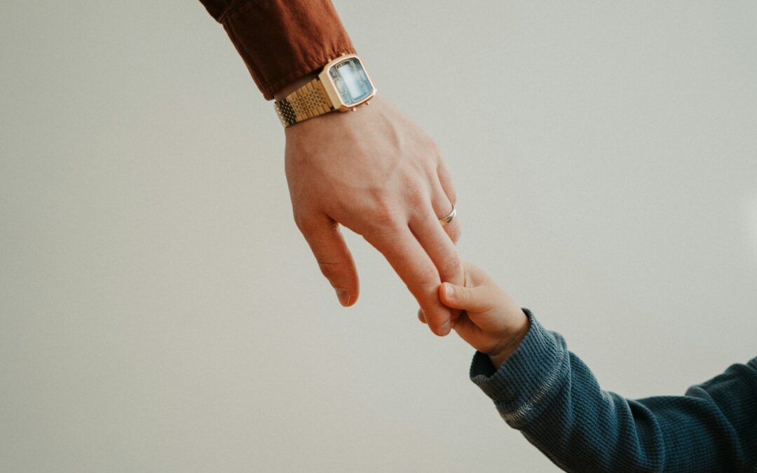 a person holding the hand of a child