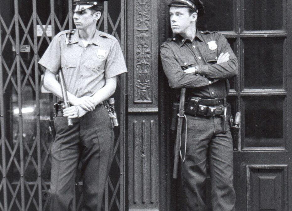 Two police officers stand guard outside a building.